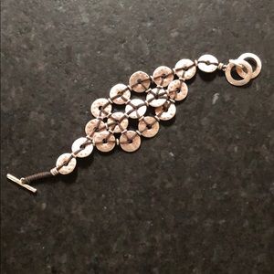 Silver and brown cord intricate bracelet.